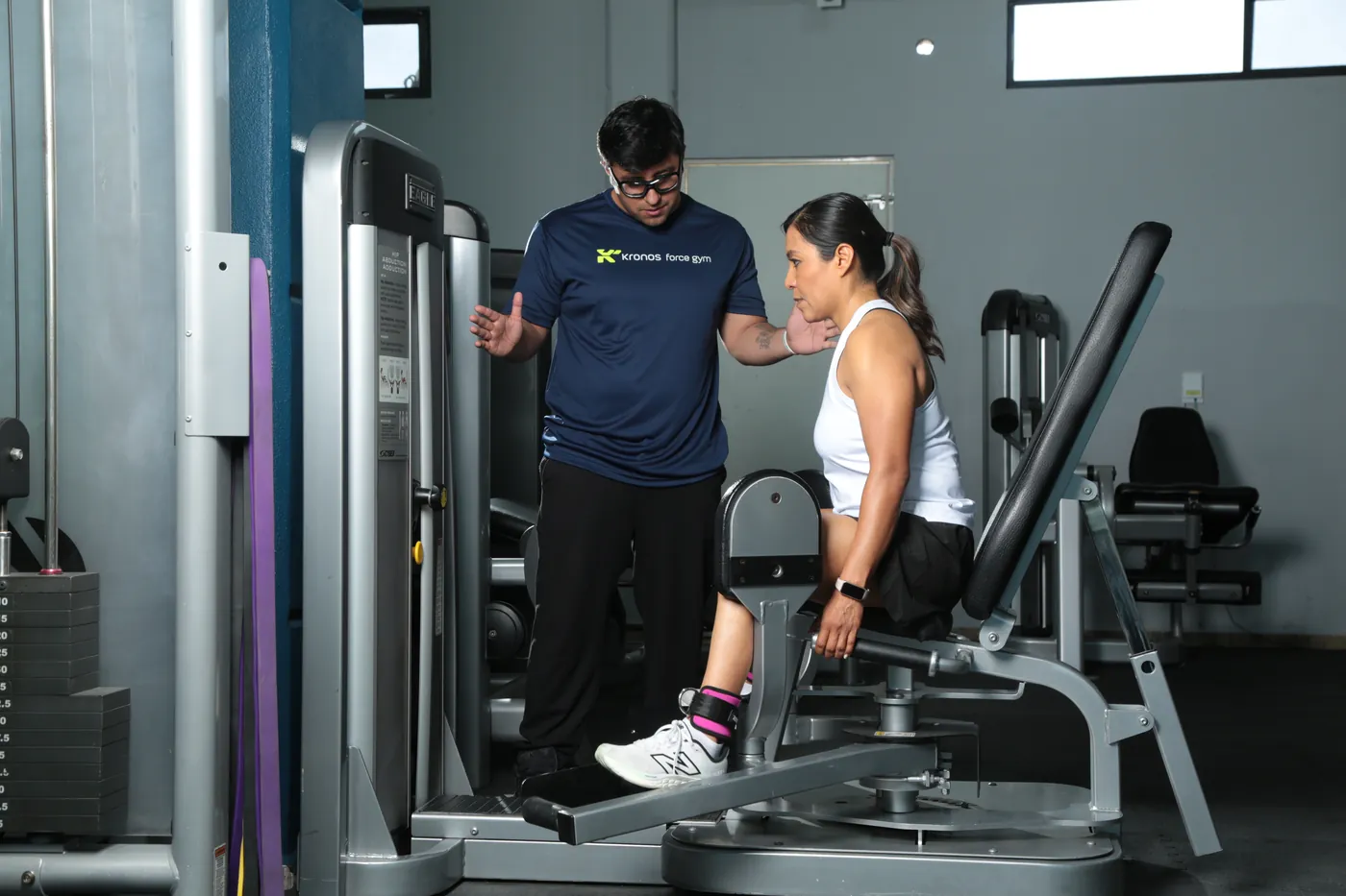 Entrenador guiando un ejercicio de fuerza en polea